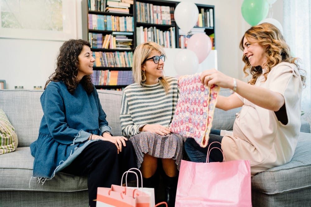 Una donna ammira un regalo ad un baby shower