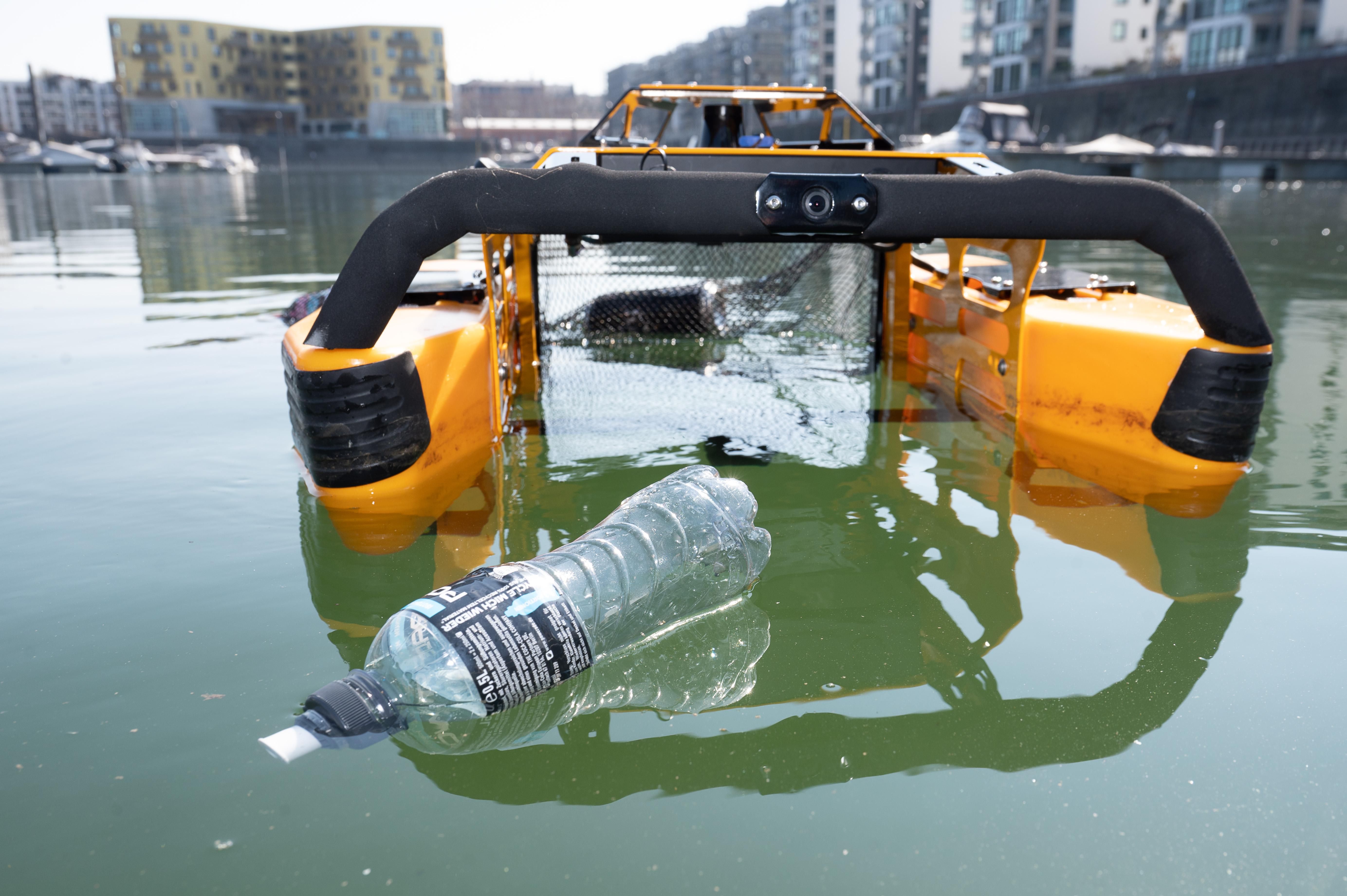 A yellow floating robot prepares to collect a plastic water bottle at the Marina Zollhafen. Zollhafen is located at the portion of the Rhine River that runs past the city of Mainz, Germany.