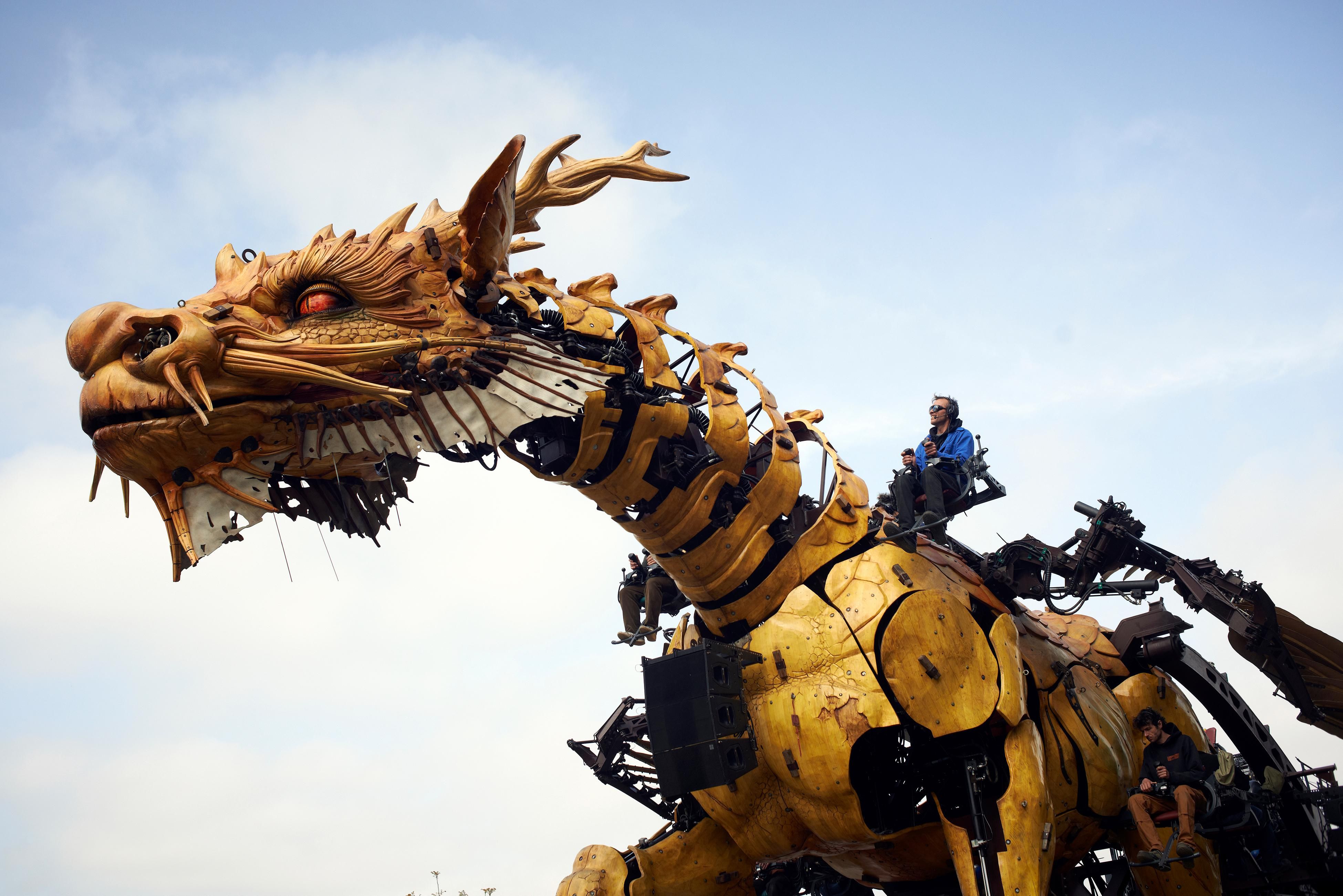 Image of a robotic dragon with a man on top of the dragon.