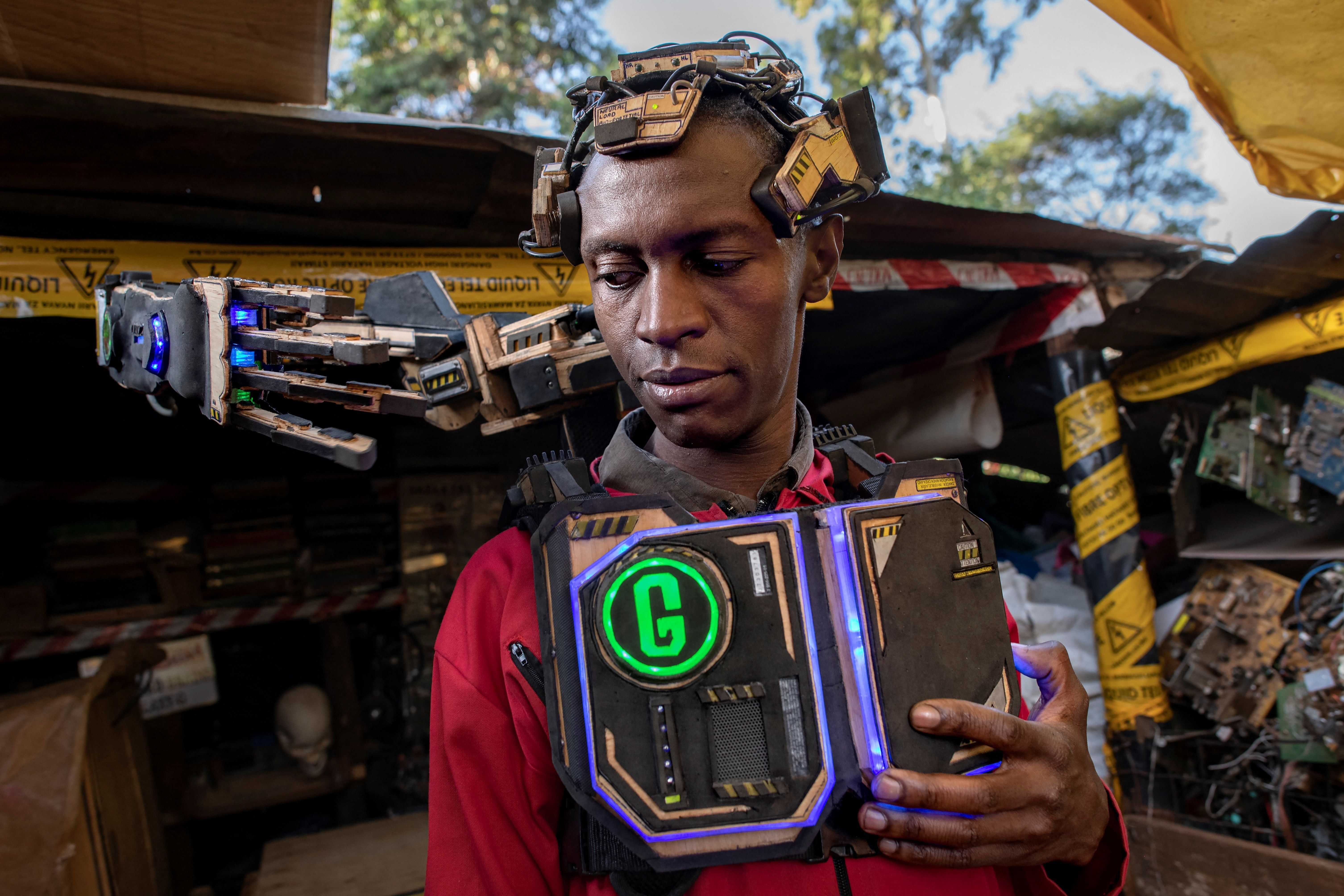 A photo of a man with various electronics parts on or attached to him.