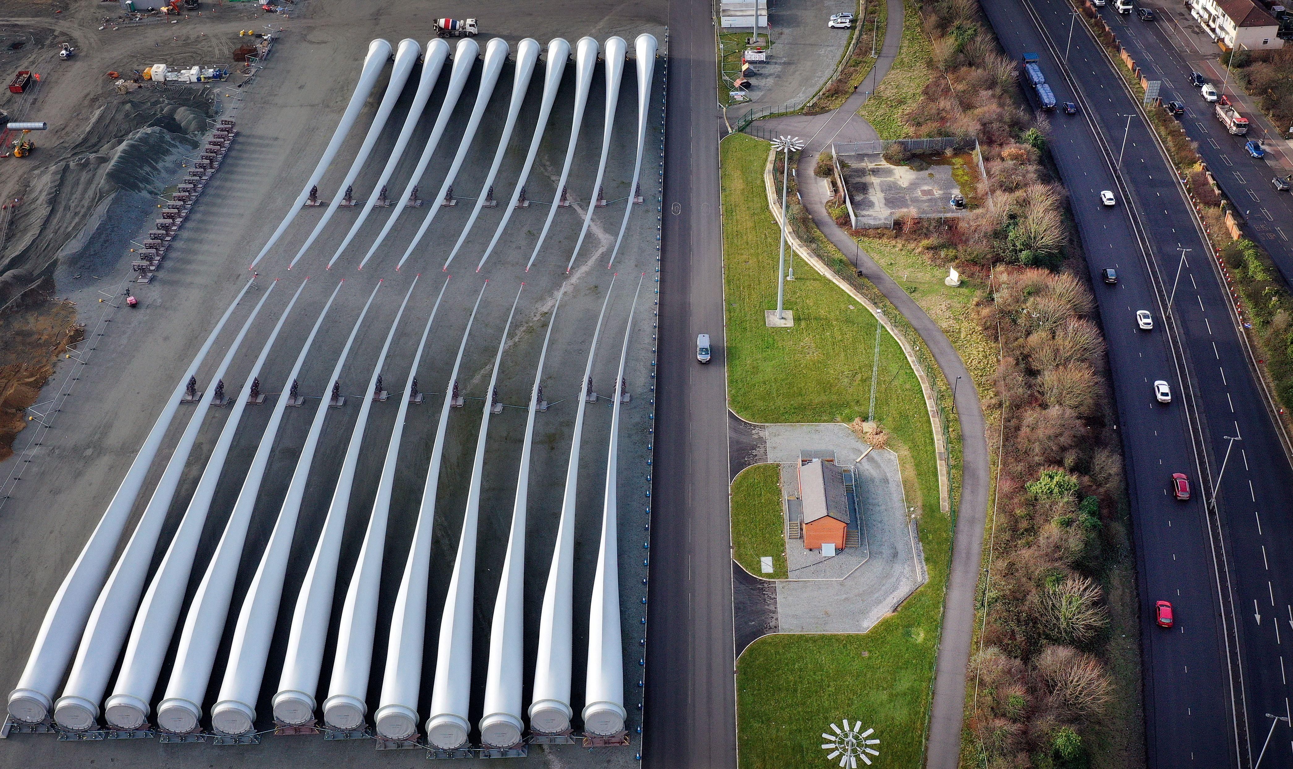 22 giant white fan blades sit parked adjacent to a highway in Hull, northeast England. The blades were manufactured for 20 to 30 years of service generating electricity on wind turbines before they\u2019re broken down and recycled for their next environmentally friendly use.
