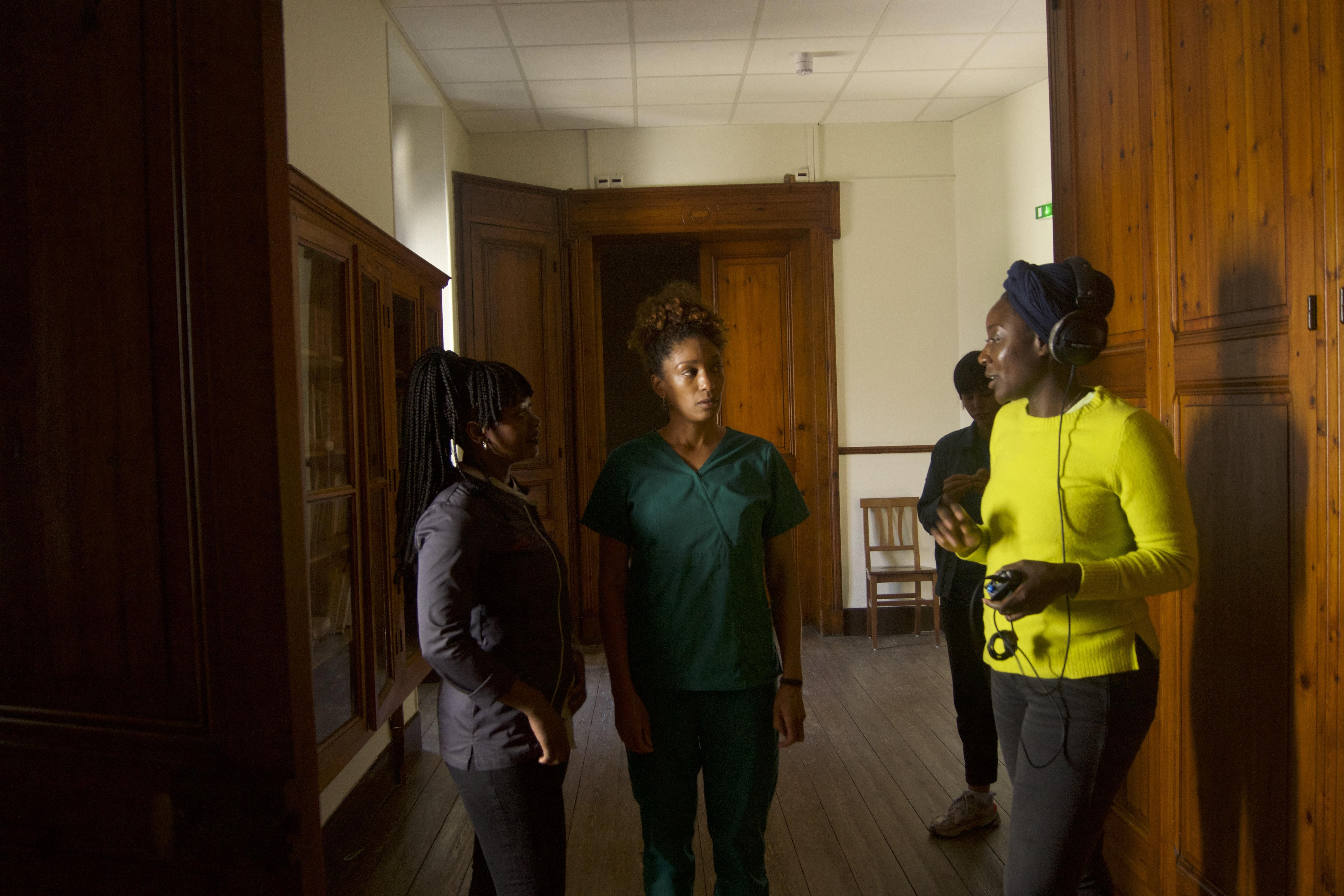 An image of the director on set talking with her two co-stars.
