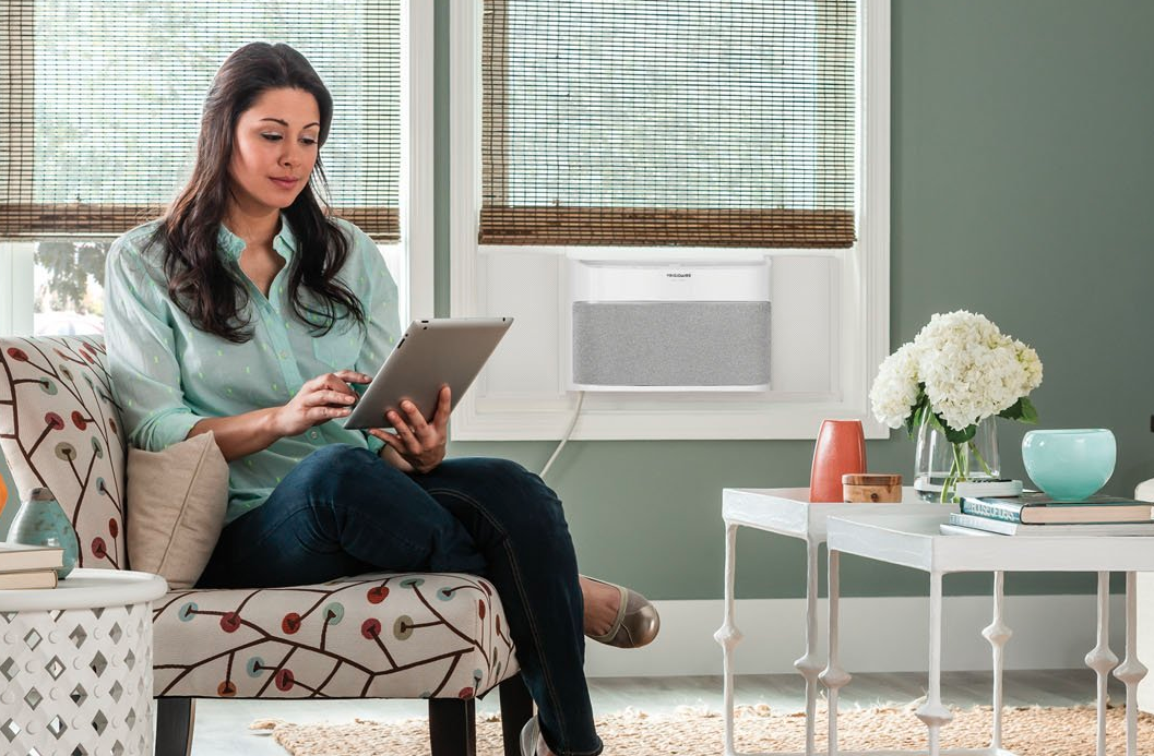 picture of a femail in a room with an Frididaire Smart Window Air Conditioner.