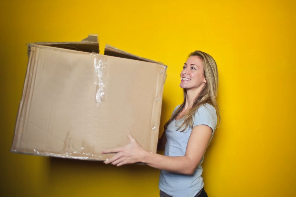 https://www.pexels.com/photo/woman-in-grey-shirt-holding-brown-cardboard-box-761999/