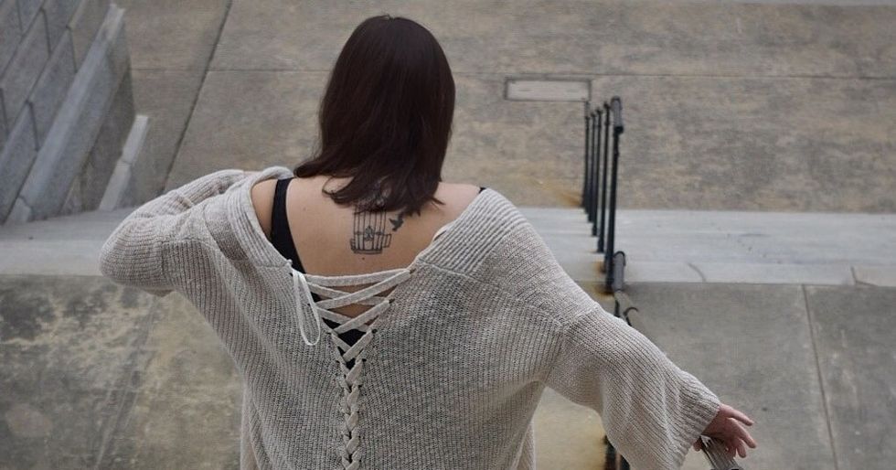 woman with bird cage tattoo