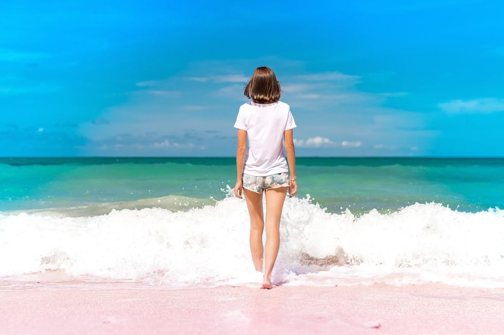 girl walking into ocean waves