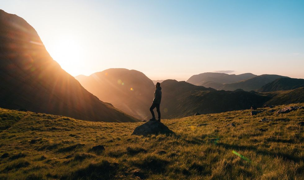https://www.pexels.com/photo/silhouette-photography-of-person-standing-on-green-grass-in-front-of-mountains-during-golden-hour-746386/
