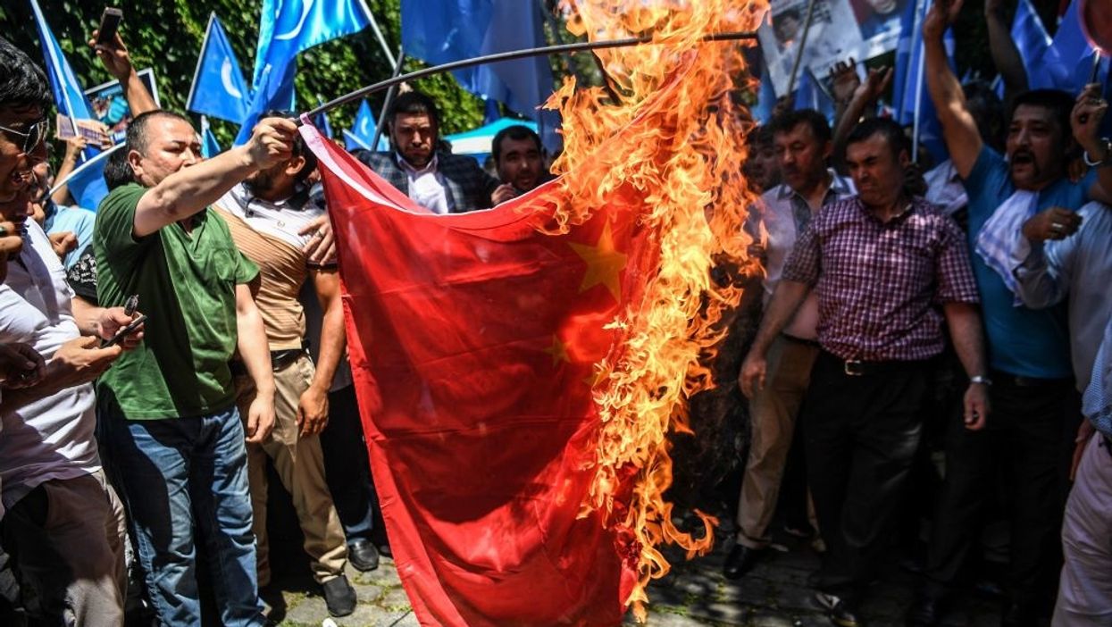 Supporters of the mostly Muslim Uighur minority and Turkish nationalists burn a Chinese flag during a protest to denounce China's treatment of ethnic Uighur Muslims during a deadly riot on July 2009 in Urumqi, in front of the Chinese consulate in Istanbul, on July 5, 2018.