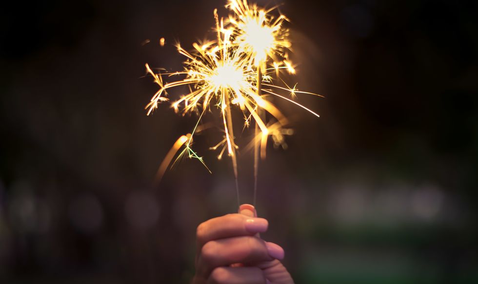 Person holding lit sparklers