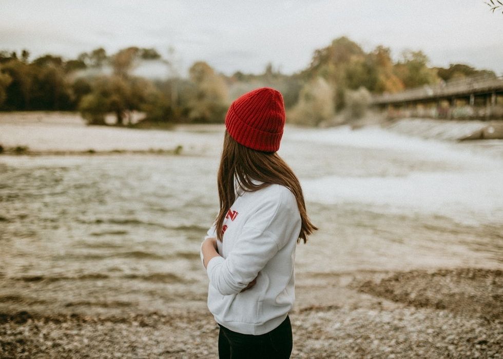 woman standing alone in red beanie