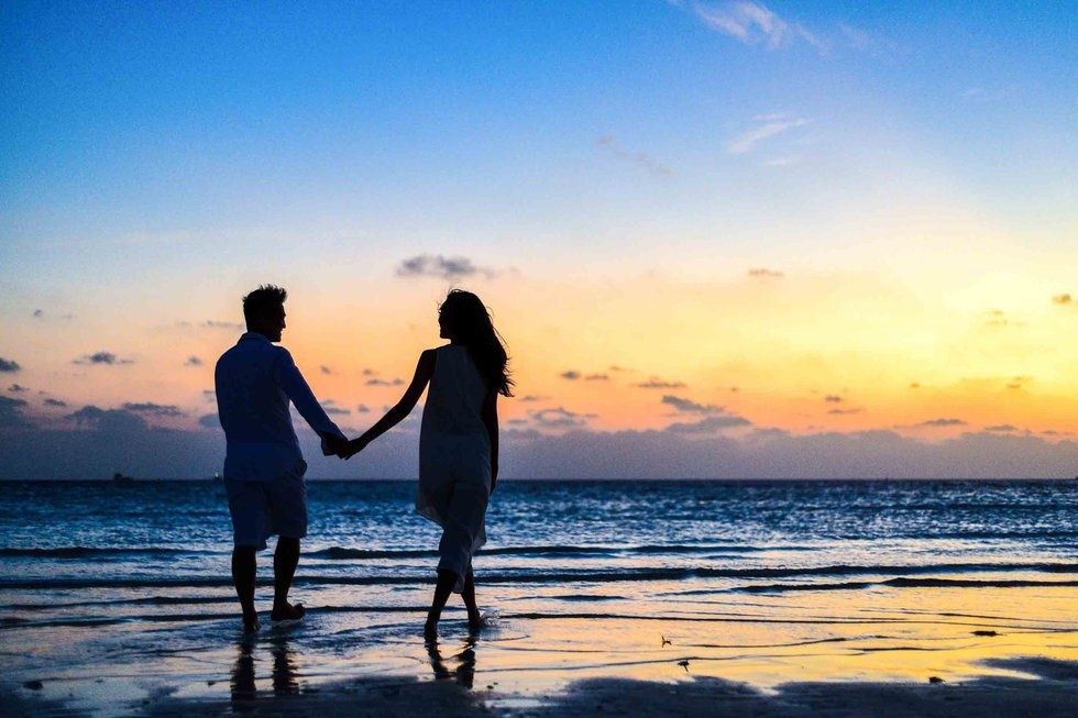 https://www.pexels.com/photo/man-and-woman-holding-hands-walking-on-seashore-during-sunrise-1024960/