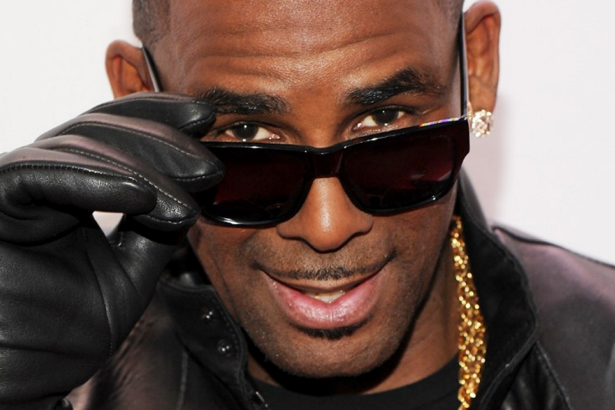 R. Kelly in black leather gloves and sunglasses looking straight ahead