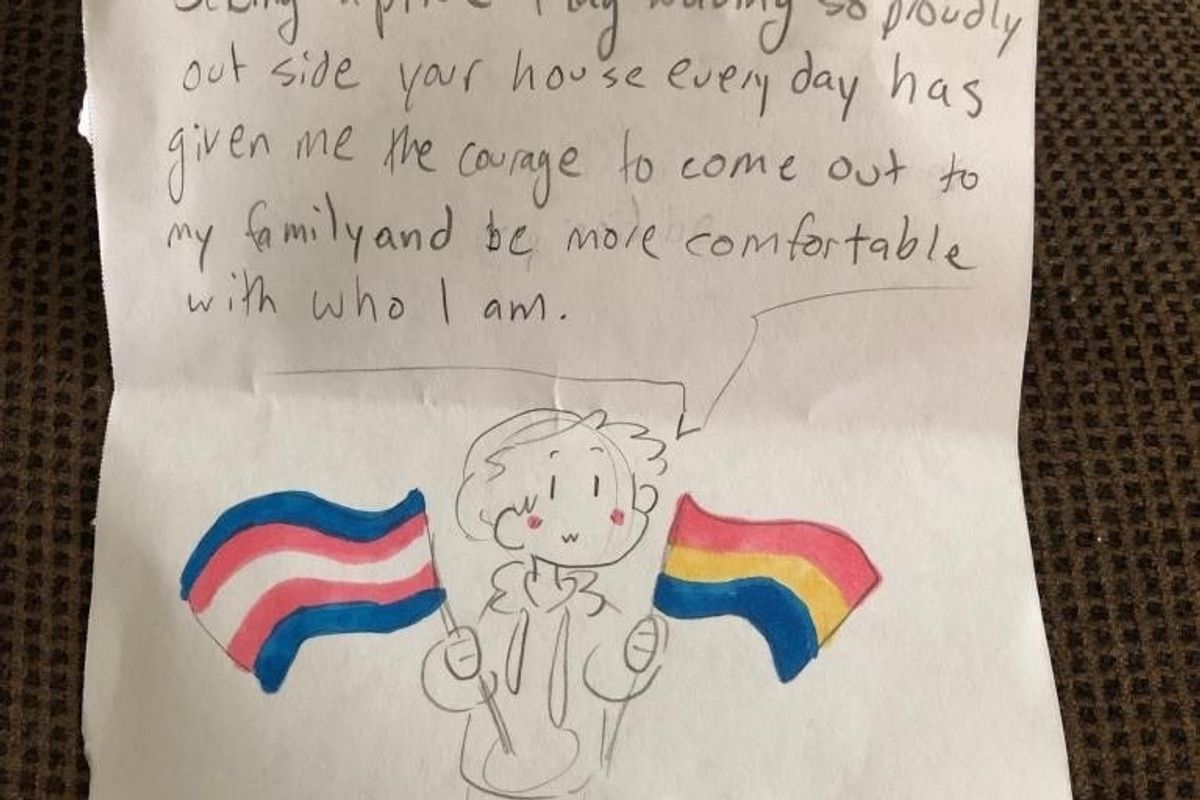 A gay couple's pride flag helped give a young teen the courage to come out to their family.