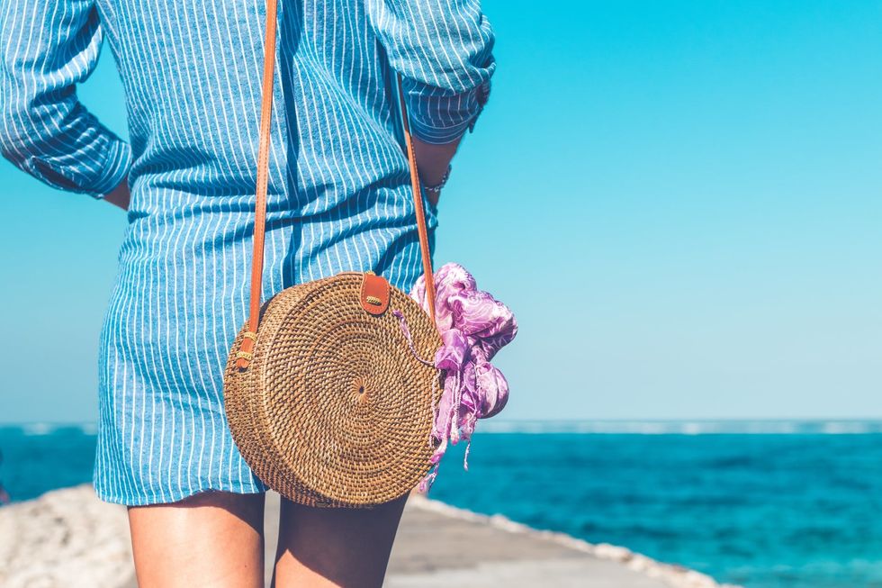 https://www.pexels.com/photo/woman-wearing-blue-and-white-striped-dress-with-brown-rattan-crossbody-bag-near-ocean-1103511/