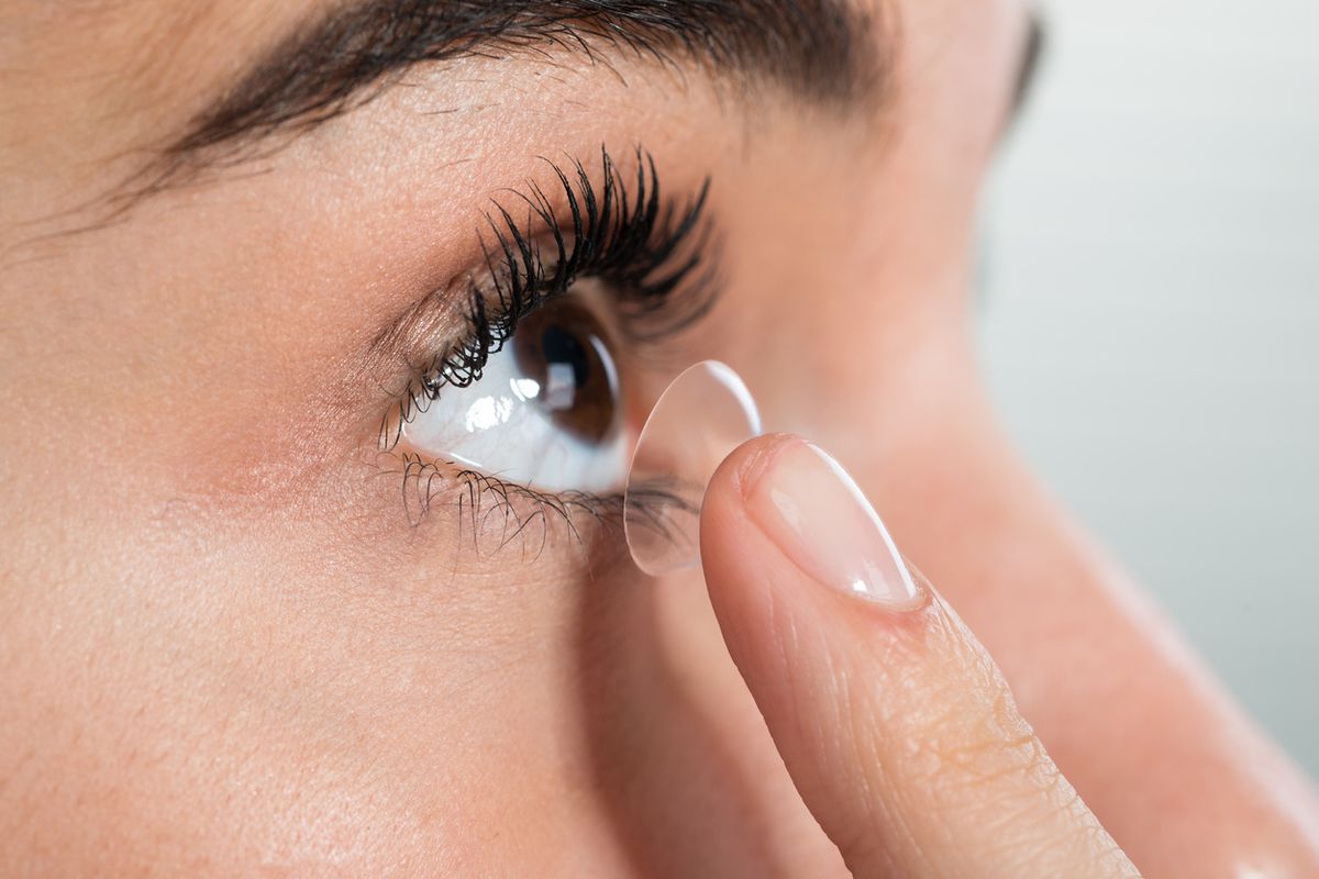 Stock image of a woman inserting a contact lens