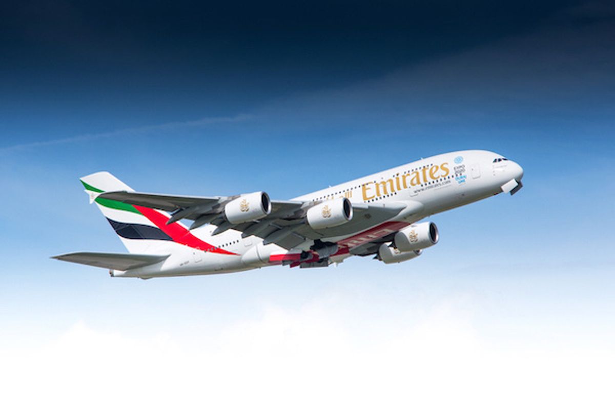 An airplane in mid-air from Emirates Airlines, with red, green and black markings 