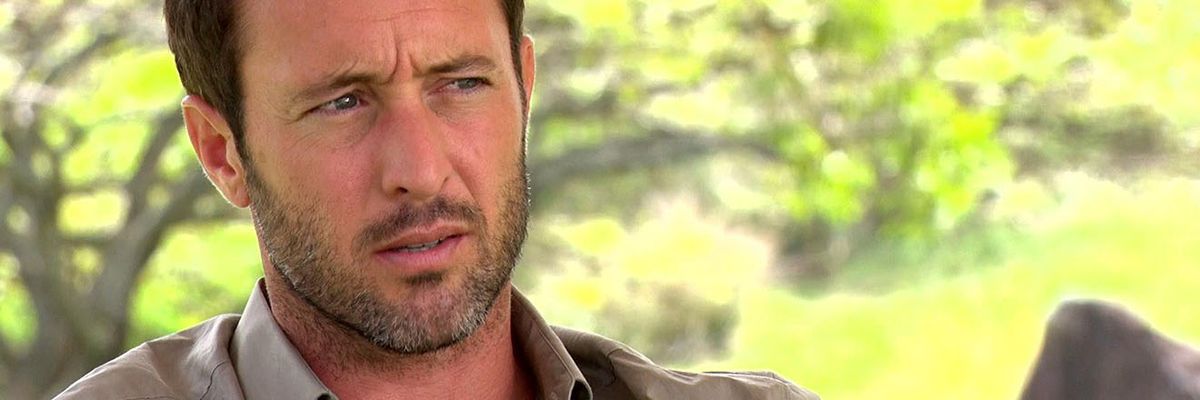 Alex O'Loughlin sits in a park and talks to an interviewer.