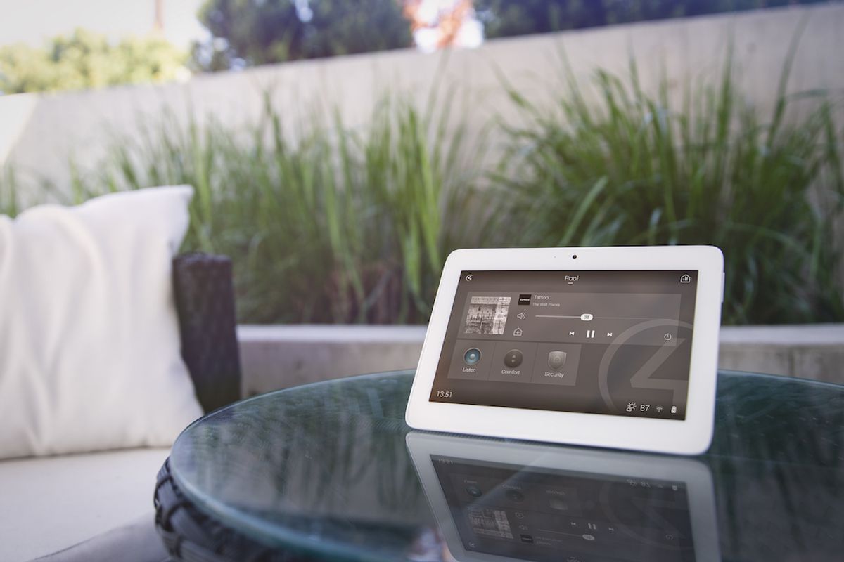 A touchscreen sitting on top of a marble table with an outdoor garden in the background