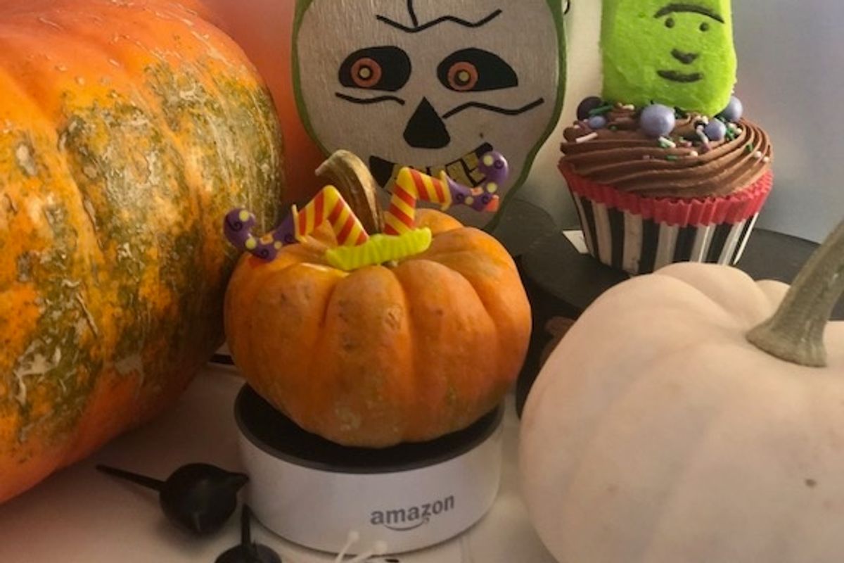 An Amazon Echo surrounded by Halloween decorations