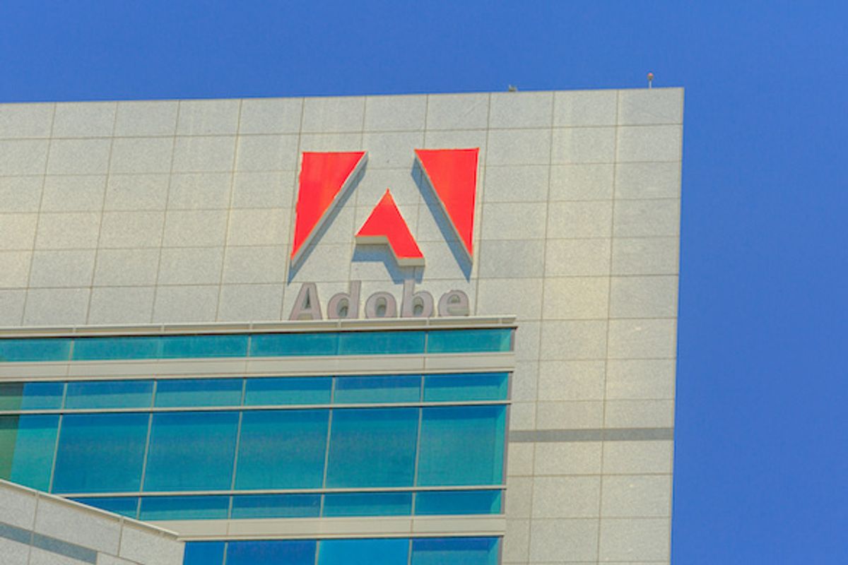 A white building with large glass windows, with the Adobe logo at the top