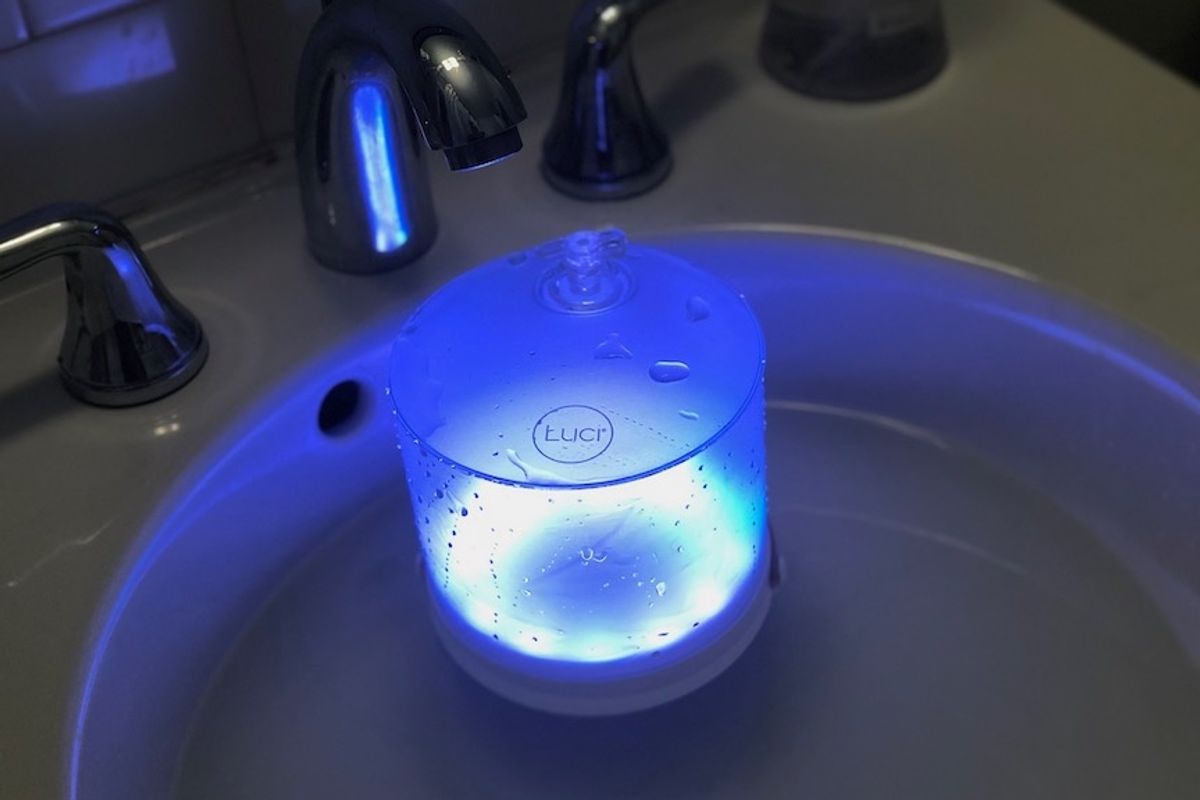 A Luci Connect solar-powered lantern floating in water