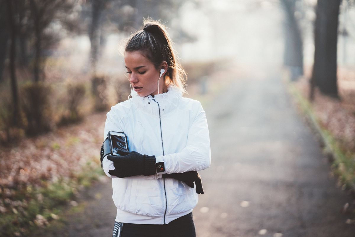 woman checking phone while out running