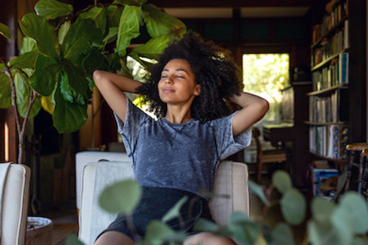A woman surrounded by plants at home and relaxing
