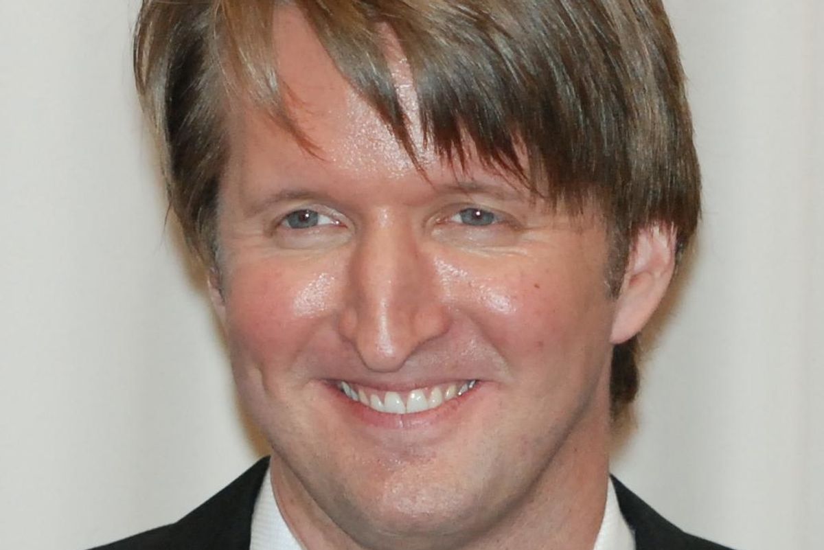 A tuxedo-clad Tom Hooper smiling for the cameras.