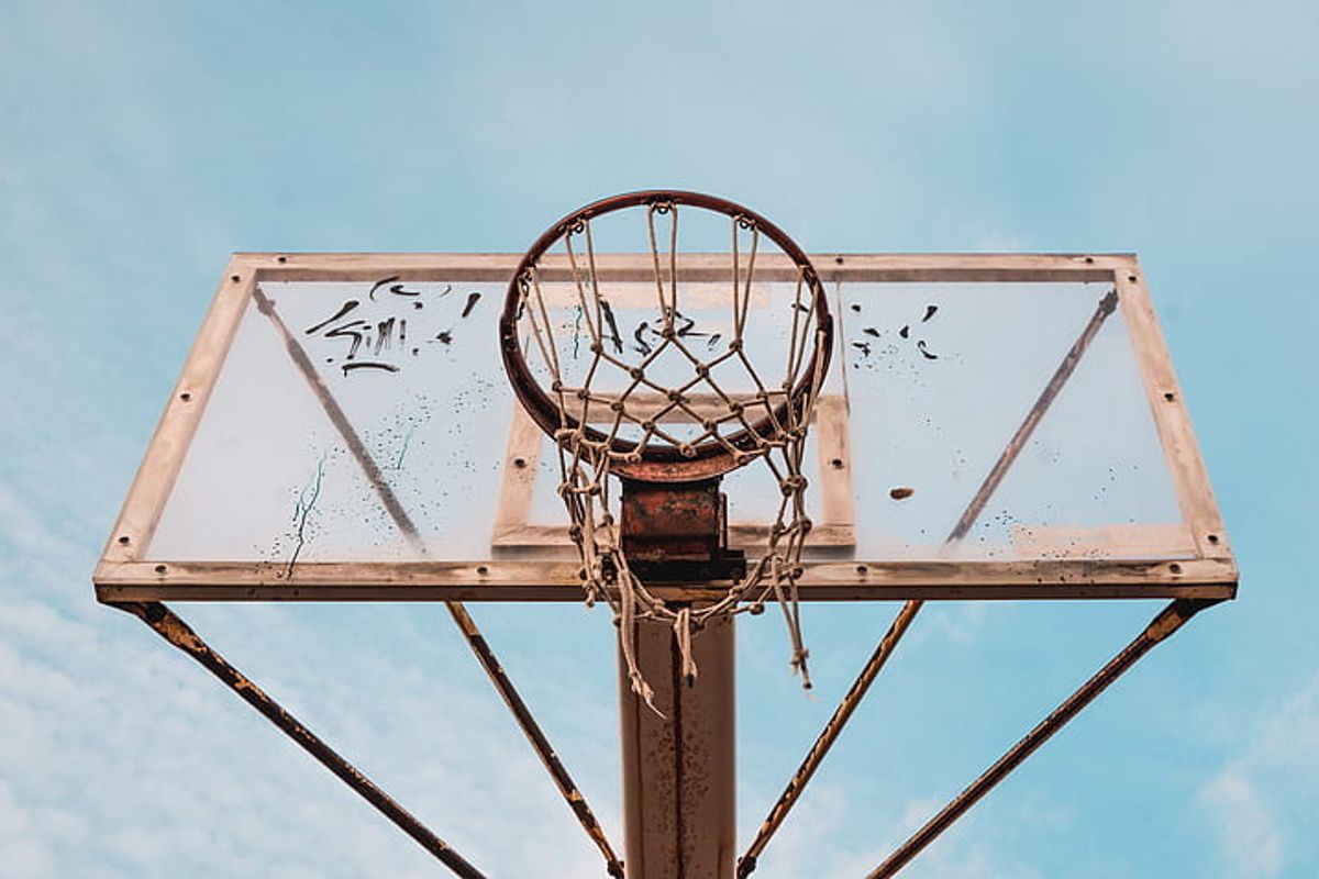 A dirty, beat-up basketball hoop sits unused.