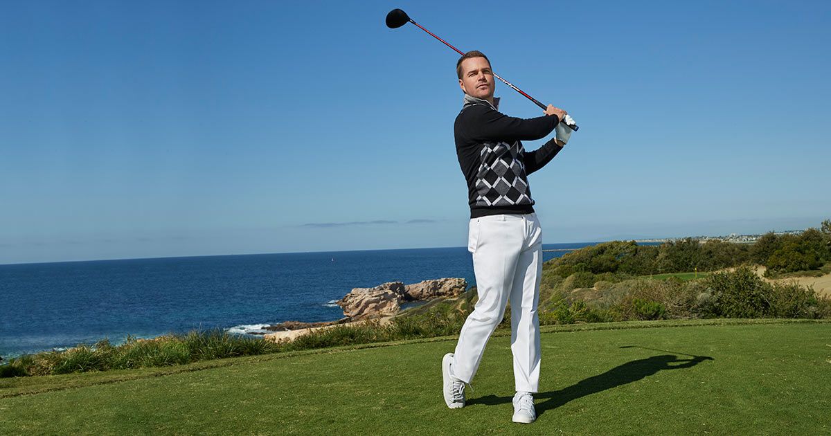 Chris O'Donnell holding a golf club and standing in front of the ocean