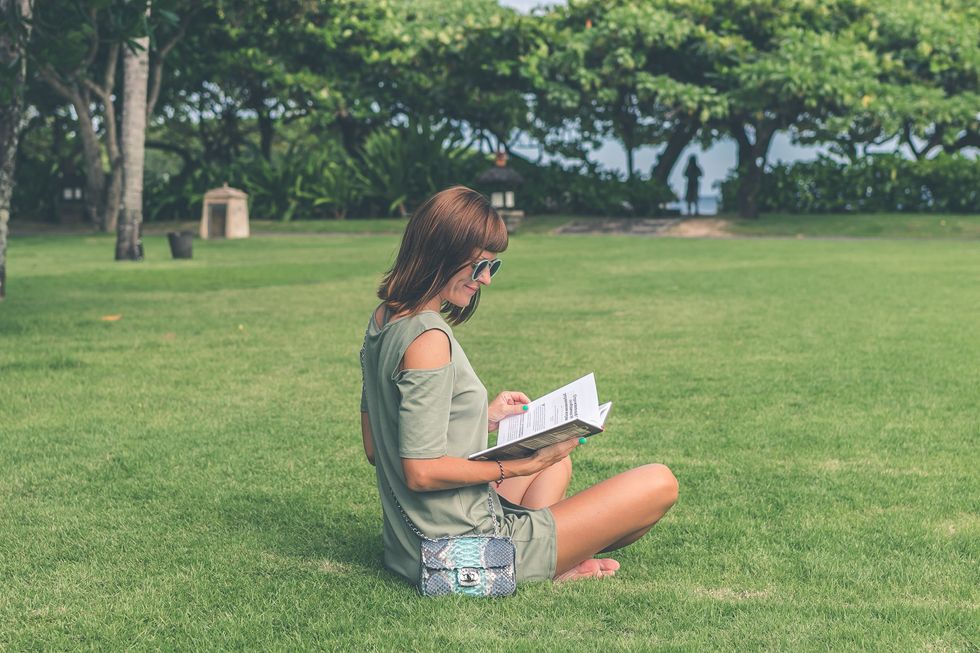 Girl reading a book in her backyard