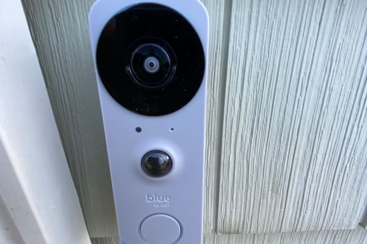 The Blue Doorbell Camera on the side of the house next to the front door.