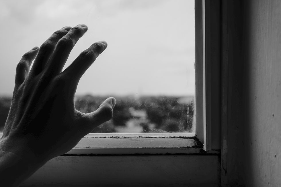 Hand reaching out towards window