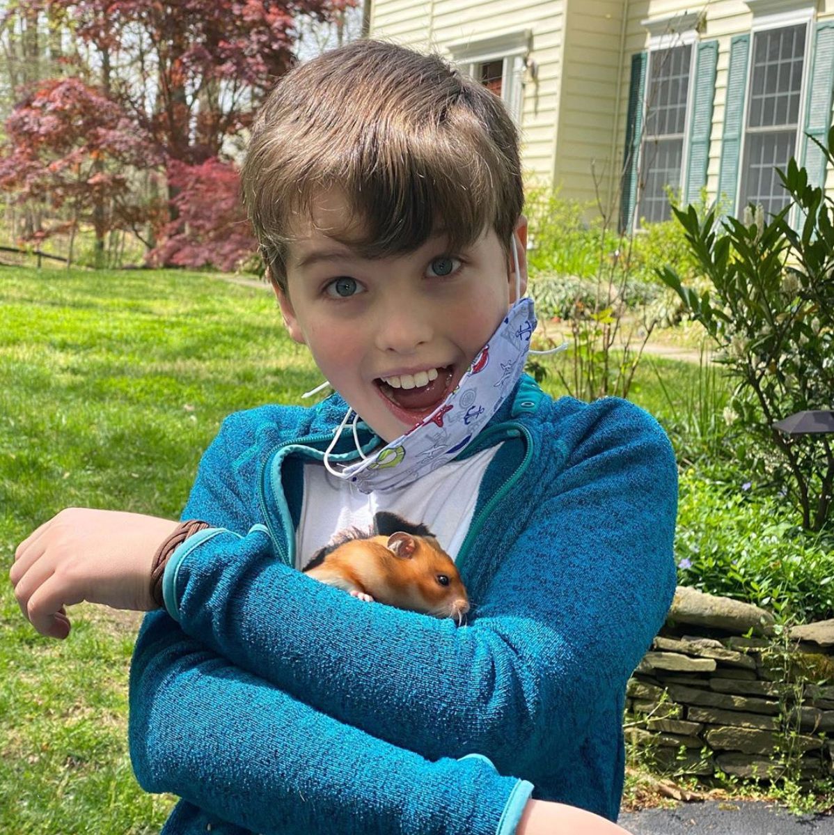 Iain Armitage stands in his front yard cradling in his arms Poppy a rescue hamster.