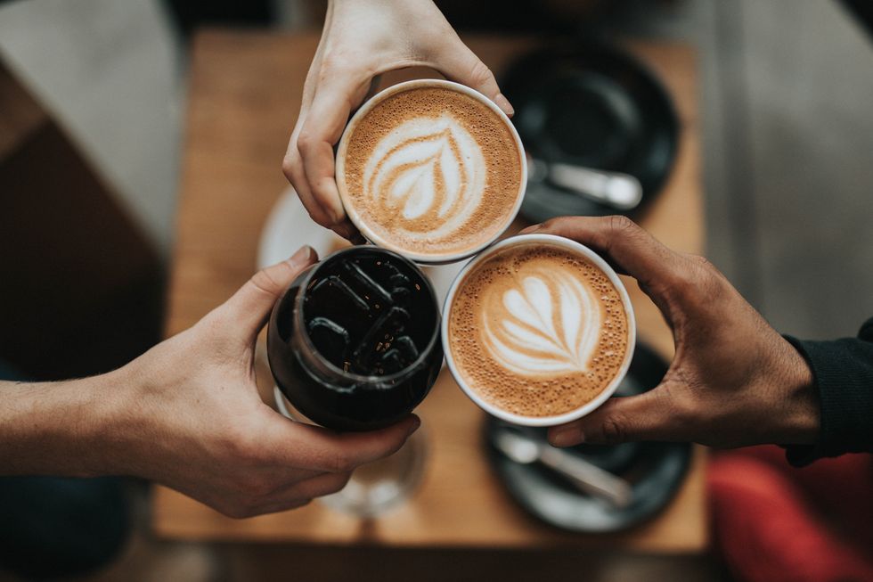 three person holding different cups of coffee