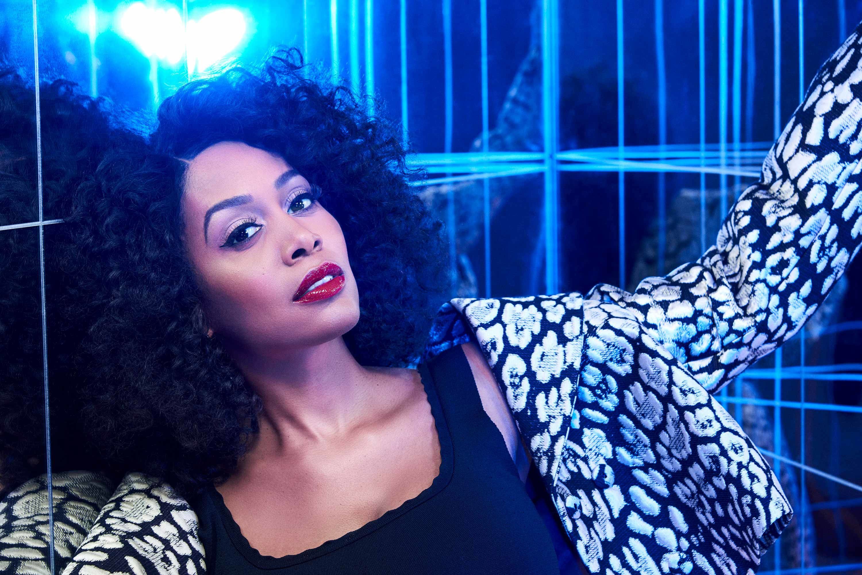 All Rise star Simone Missick wears an embroidered jacket in a stark dark tiled corner.
