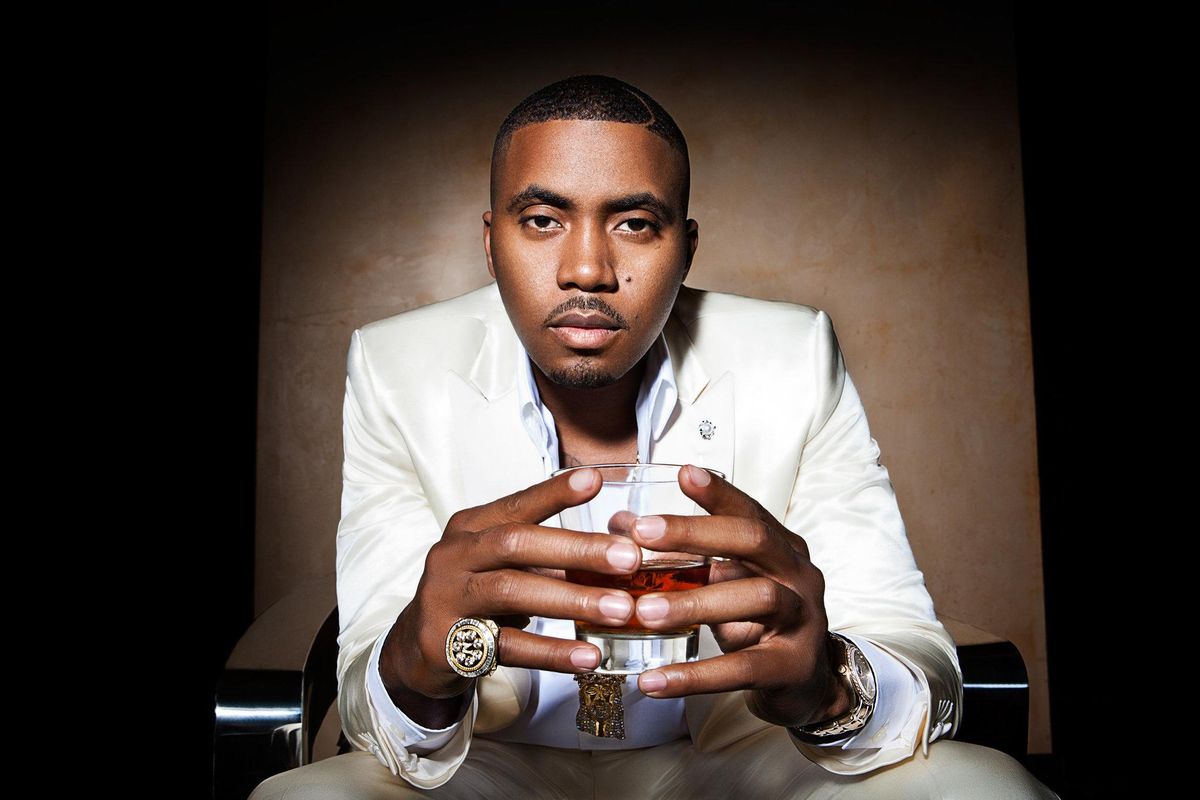 Nas holding a glass of alcohol