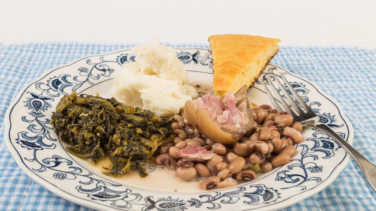 A plate of collard greens, mashed potatoes, cornbread and black-eyed peas.
