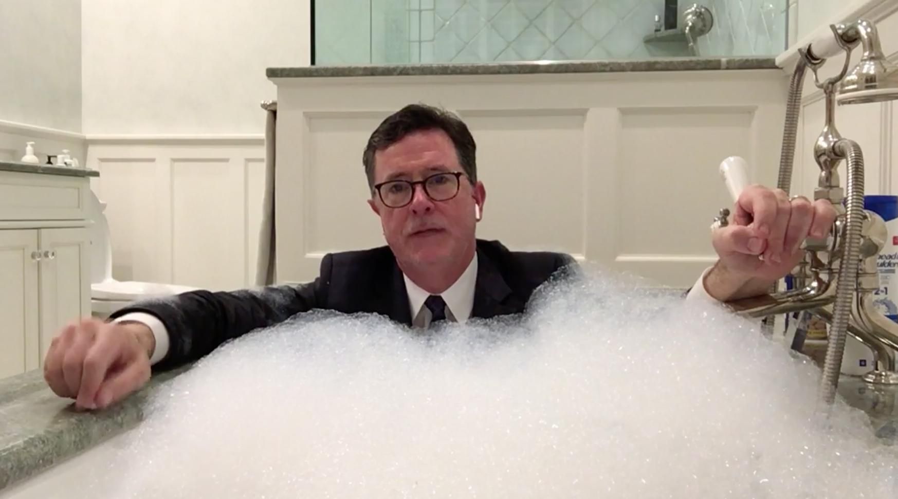 Stephen Colbert in a suit in a bubble bath