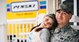 Soldier with daughter and a Penske truck in background