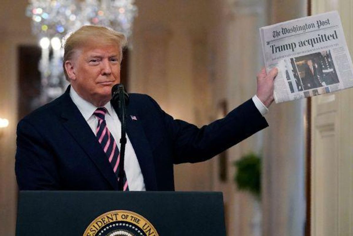 Trump posing with a news paper reading "Trump Acquitted" after his first Impeachment Trial