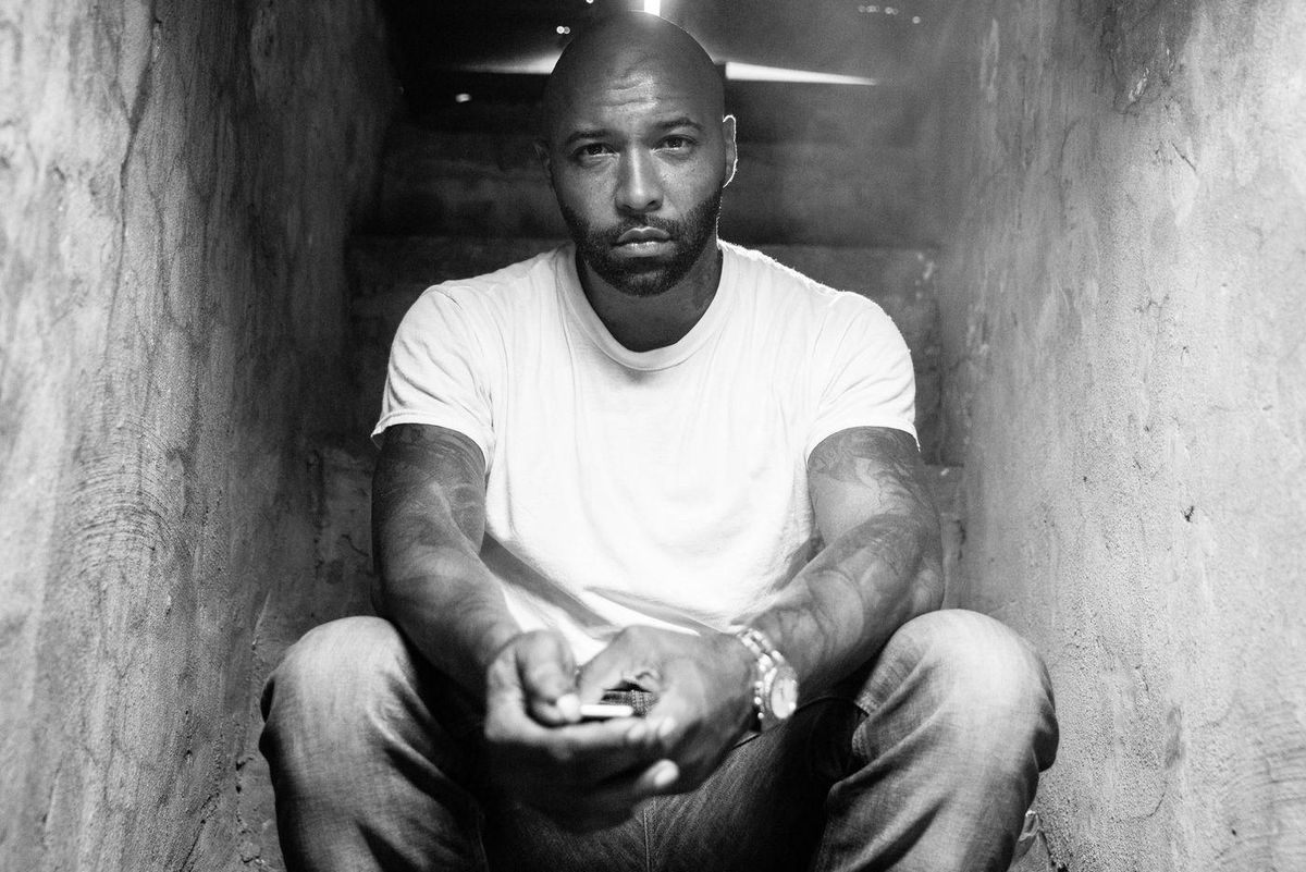 Joe Budden sitting on steps in a Black and White Photo