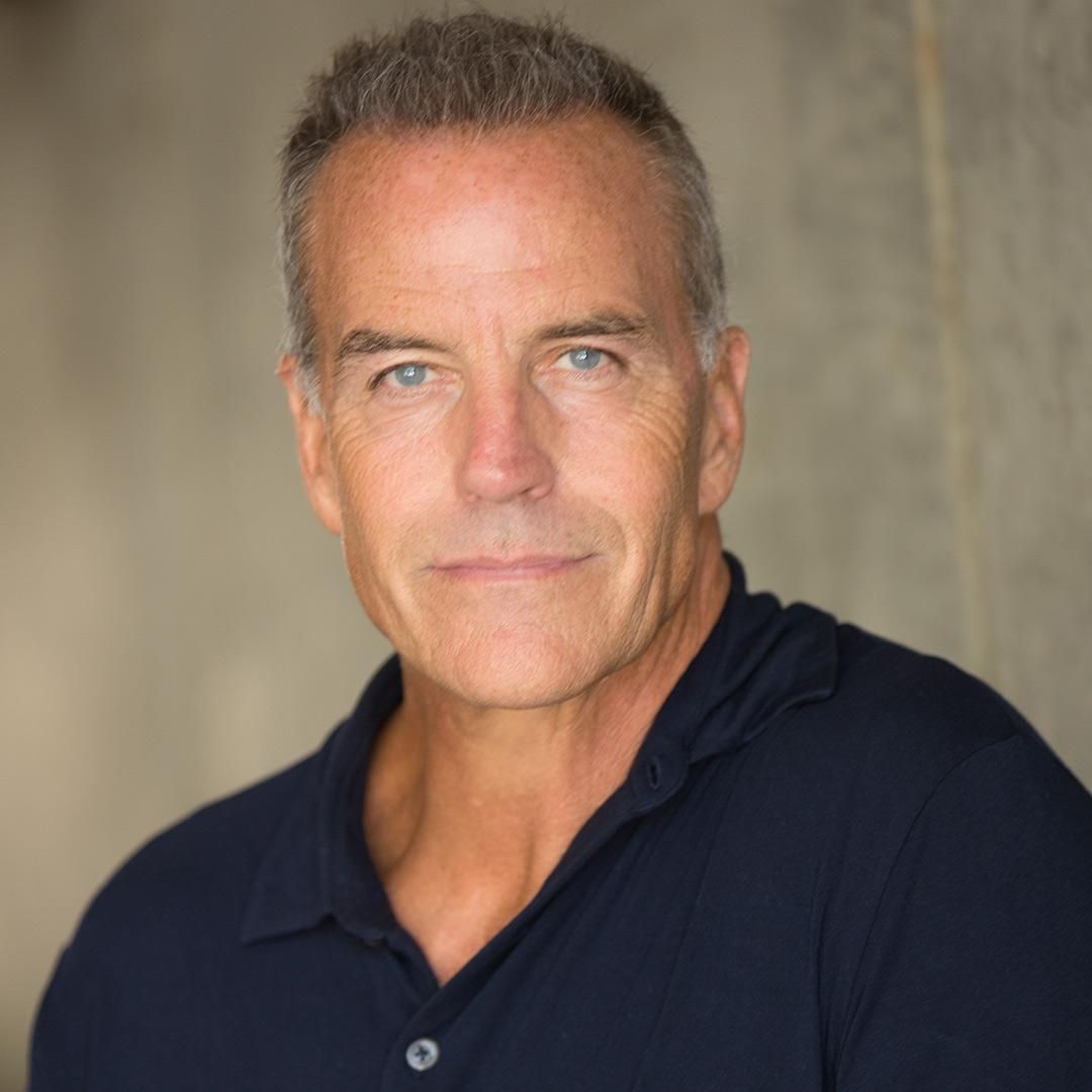 Richard Burgi of The Young and the Restless posing for the camera in a navy button down