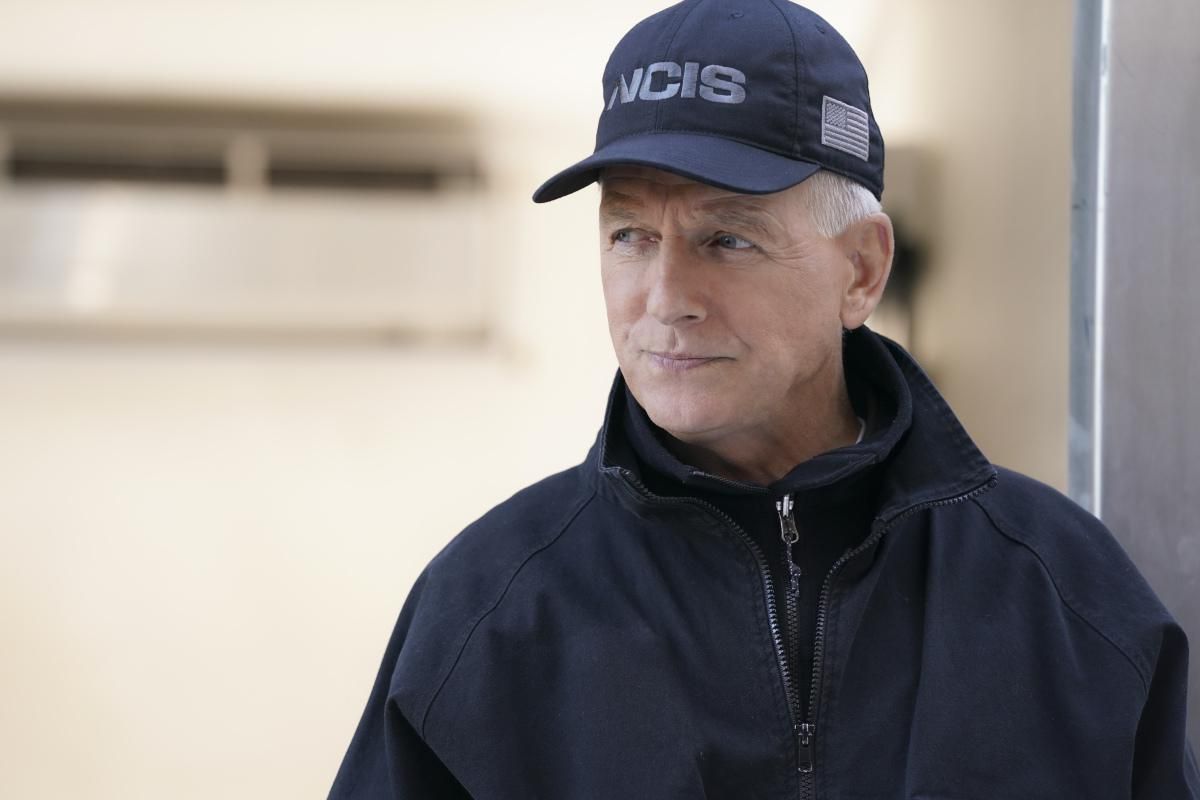 Mark Harmon as Gibbs wearing a navy blue NCIS hat and jacket