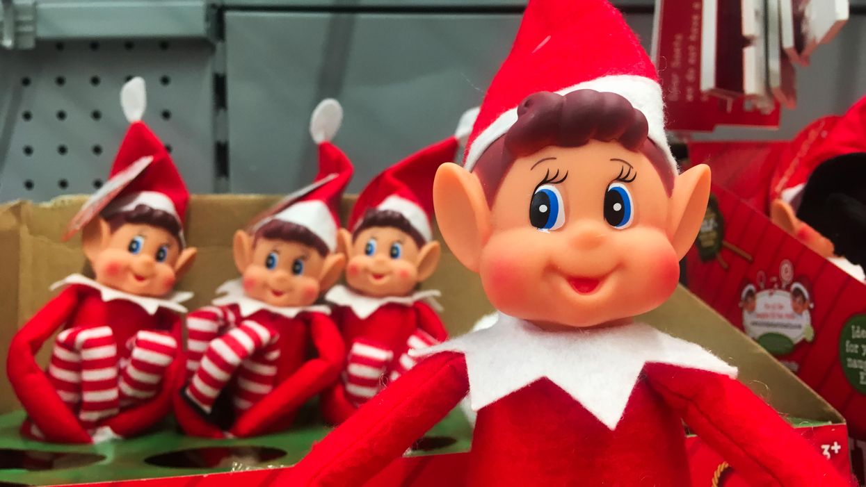 Four Elf on the Shelf dolls are on a shelf in a store.
