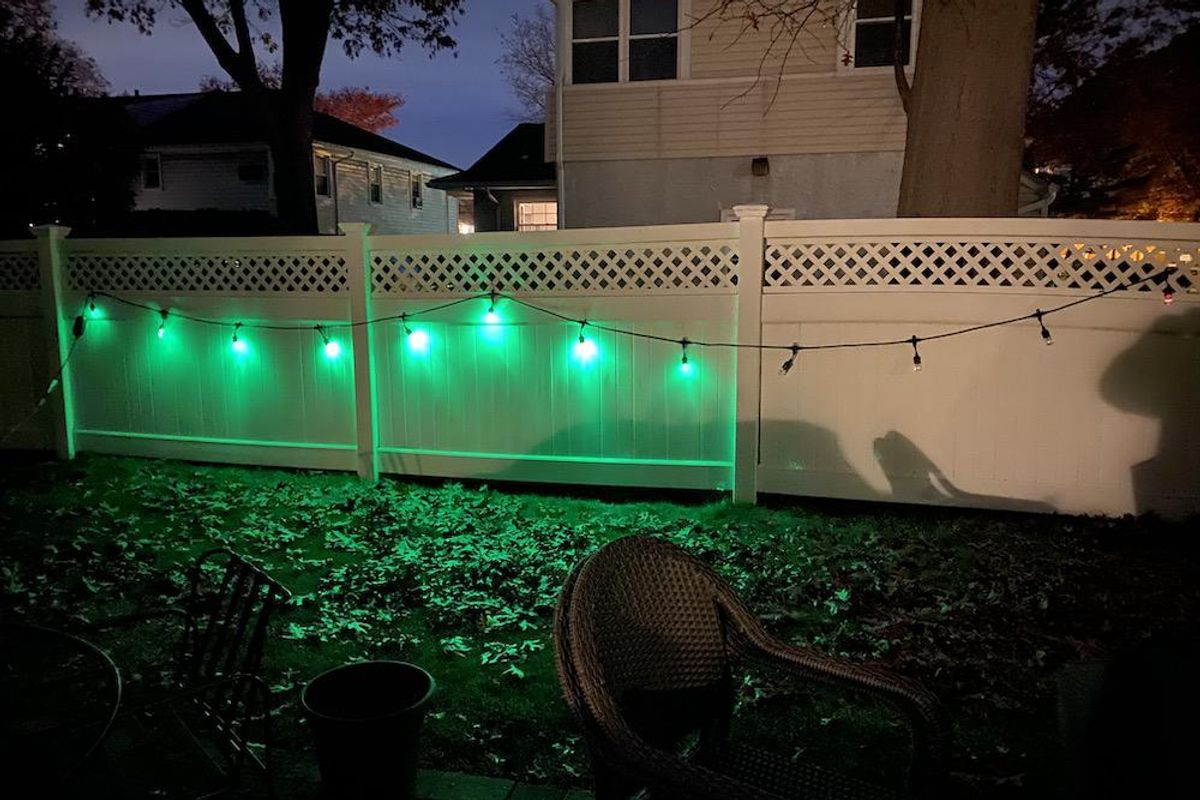 Enbrighten LED Wi-Fi Smart Cafe Lights installed on a fence outside.