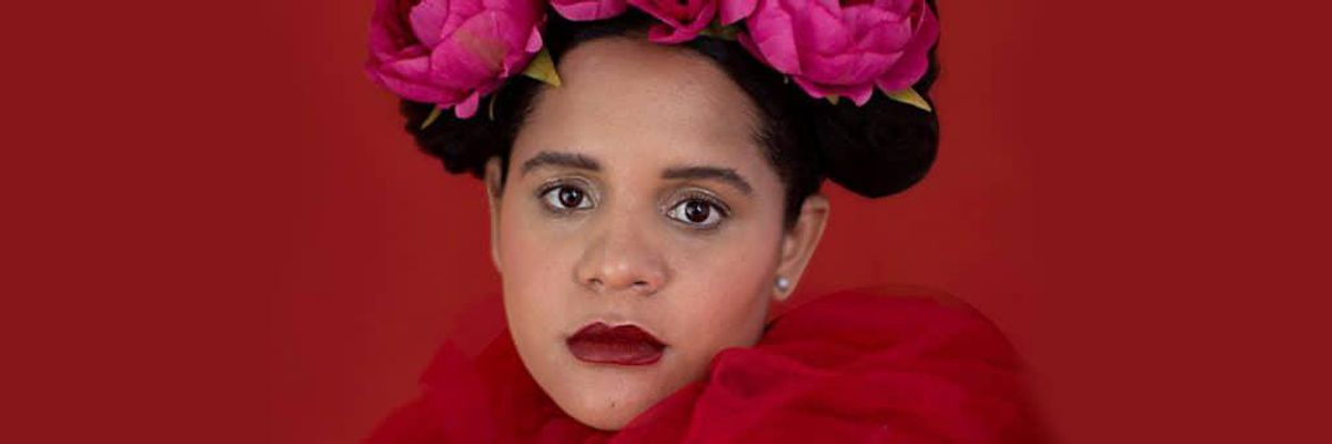 Lido Pimienta in front of a red background.