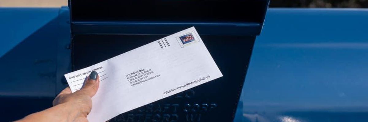 Voting mail being put in the mailbox.