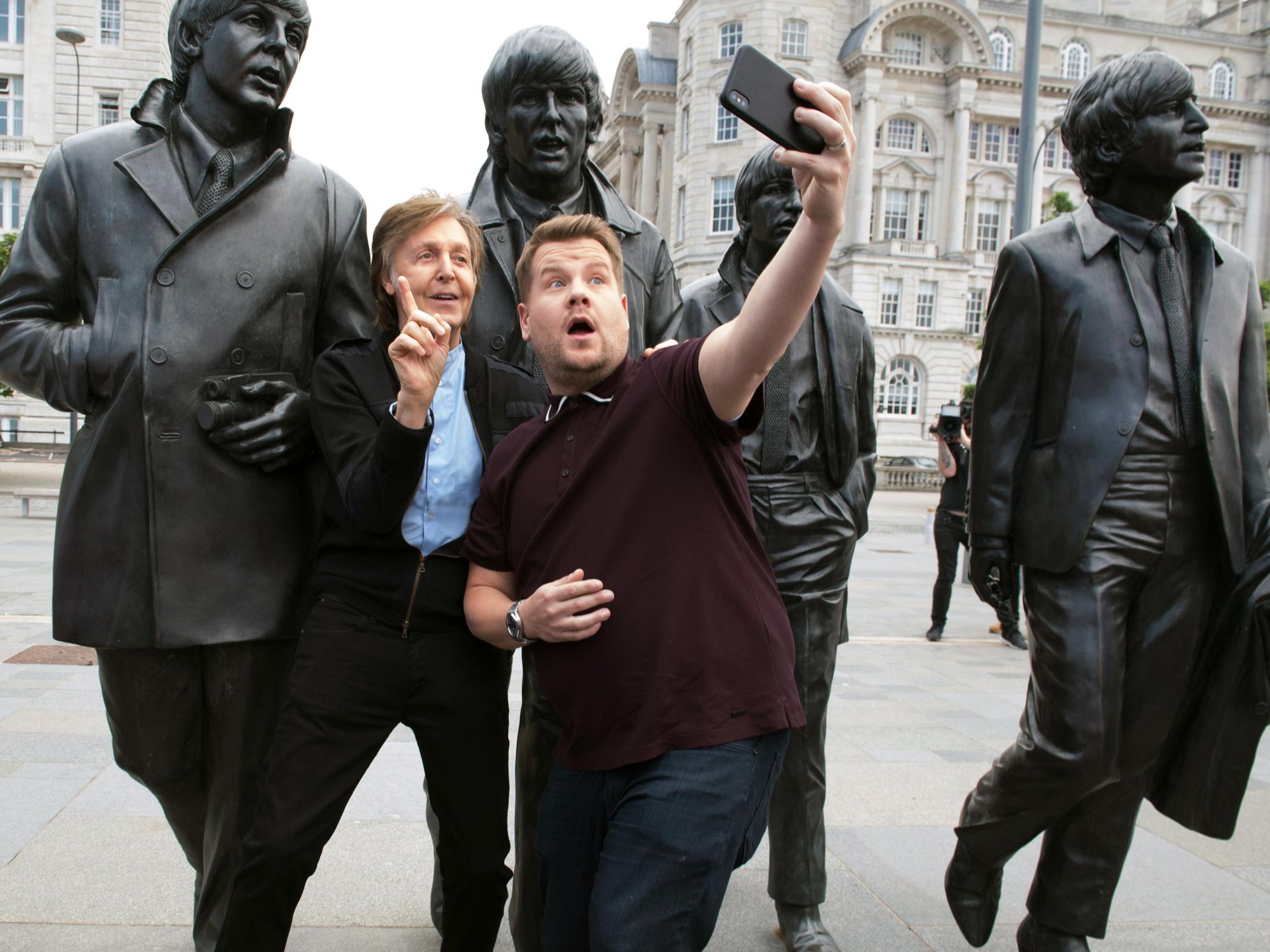 Paul McCartney and James Corden posing for a selfie in London in front of a Beatles statue