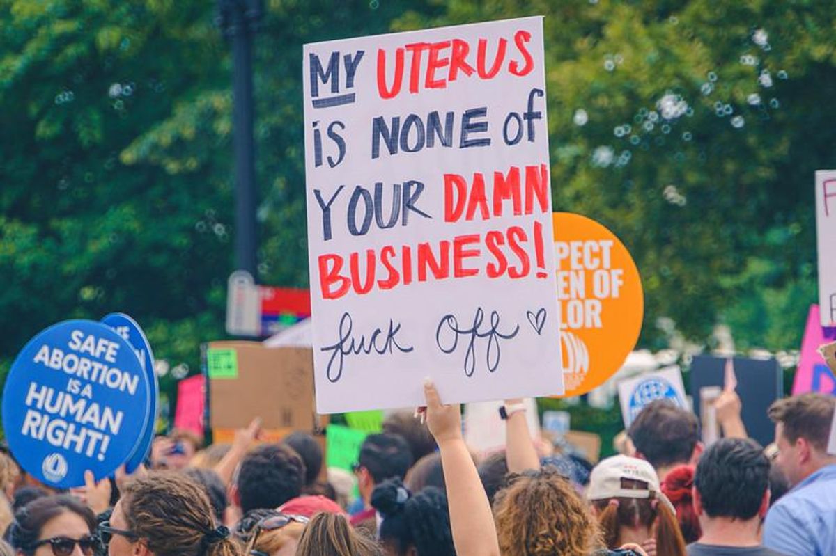Protest sign reading 'My uterus is none of your damn business! Fuck off' (with a little heart after 'fuck off')